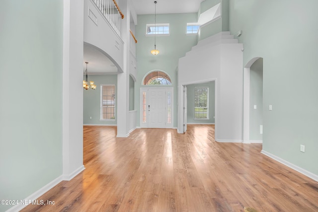 entrance foyer featuring light hardwood / wood-style floors, a healthy amount of sunlight, and a high ceiling