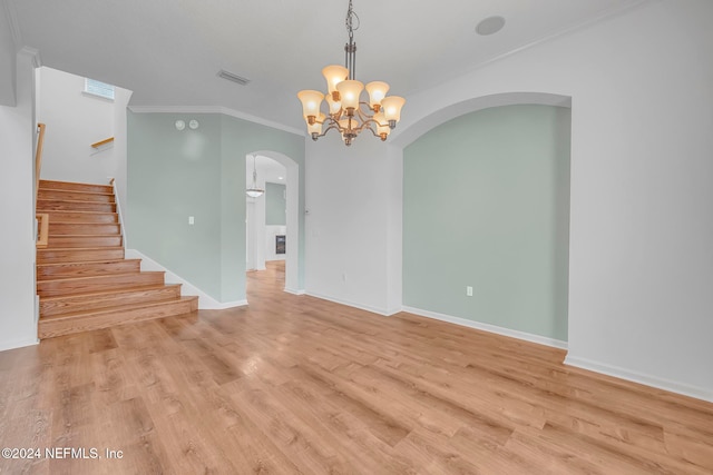 spare room featuring light hardwood / wood-style flooring, a notable chandelier, and crown molding