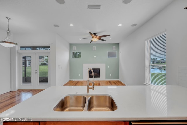 kitchen featuring pendant lighting, light hardwood / wood-style floors, a wealth of natural light, and sink