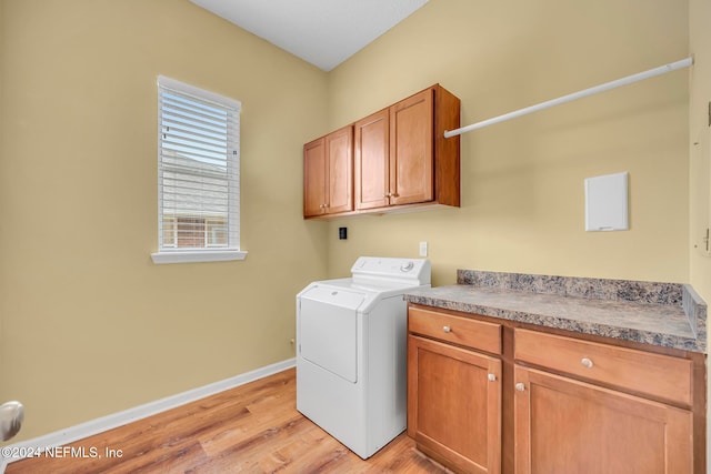 laundry area featuring cabinets, light hardwood / wood-style floors, and washer / dryer