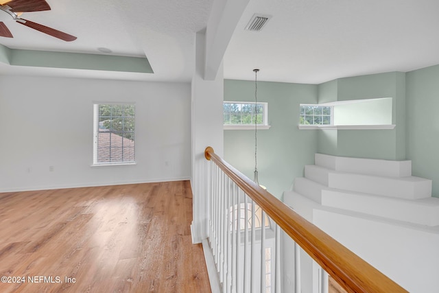 hallway featuring a textured ceiling, light wood-type flooring, and a chandelier