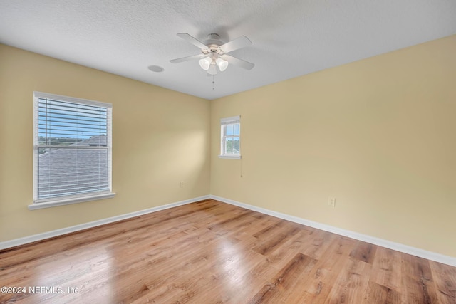 empty room with light wood-type flooring, a textured ceiling, and ceiling fan