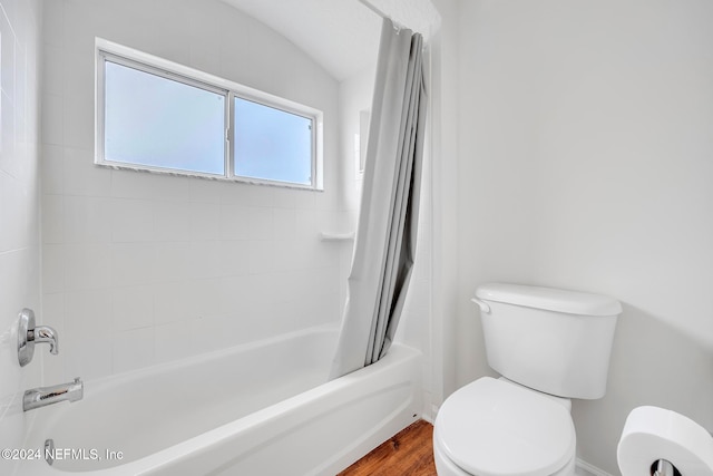 bathroom featuring wood-type flooring, toilet, shower / tub combo, and vaulted ceiling