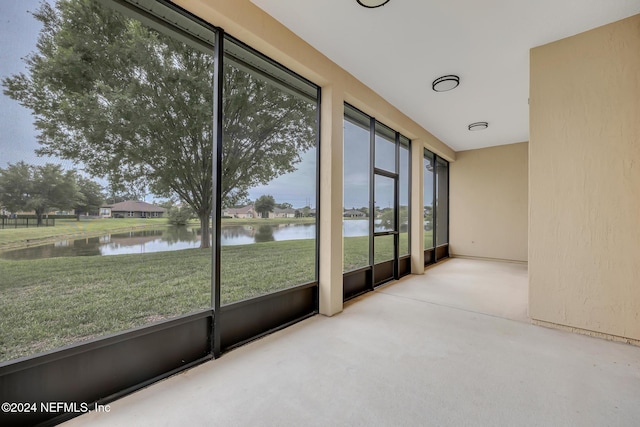 unfurnished sunroom with a water view