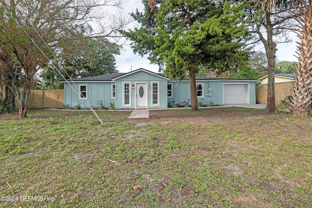 ranch-style house with a garage and a front lawn