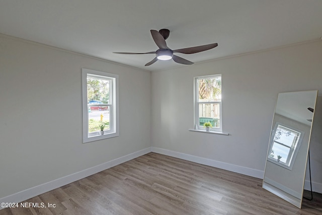 empty room featuring a wealth of natural light, ceiling fan, and light hardwood / wood-style flooring