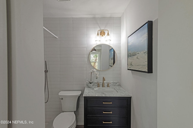 bathroom featuring tile walls, vanity, and toilet