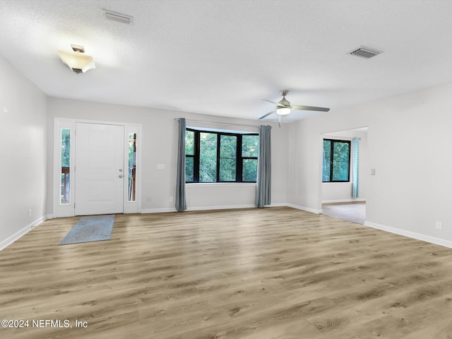 entryway featuring wood-type flooring, ceiling fan, and a textured ceiling