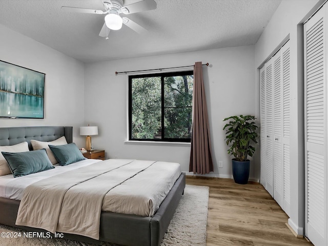 bedroom with ceiling fan, a textured ceiling, and light hardwood / wood-style floors