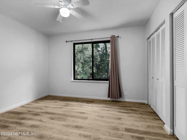 unfurnished bedroom featuring a textured ceiling, light hardwood / wood-style flooring, ceiling fan, and a closet