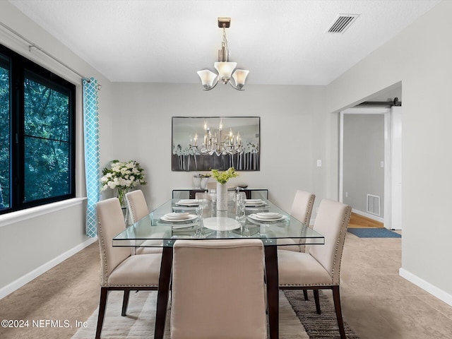 dining space with a chandelier and a barn door