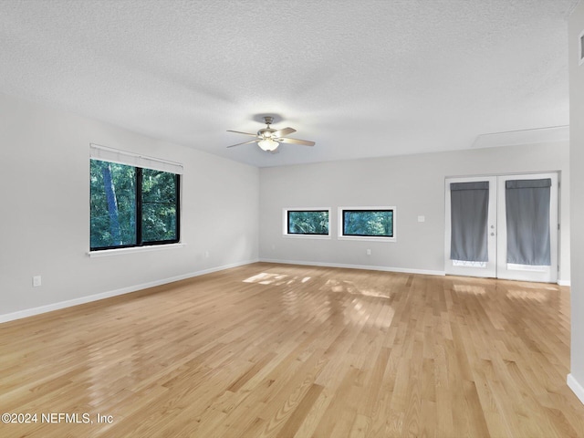 unfurnished living room with ceiling fan, a textured ceiling, and light wood-type flooring