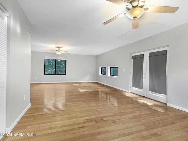 unfurnished room featuring a wealth of natural light, ceiling fan, and light hardwood / wood-style flooring