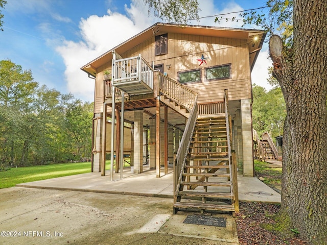 back of house featuring a deck and a patio