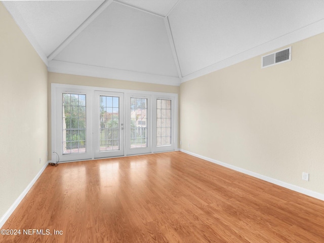 unfurnished room with high vaulted ceiling and light wood-type flooring