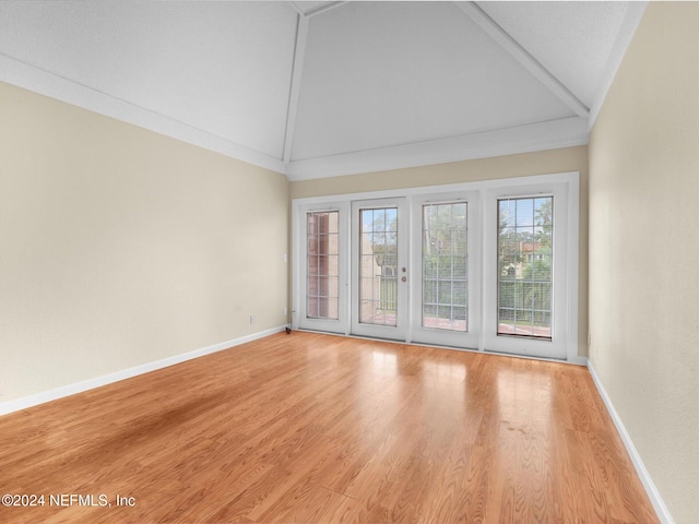 empty room with high vaulted ceiling and light wood-type flooring