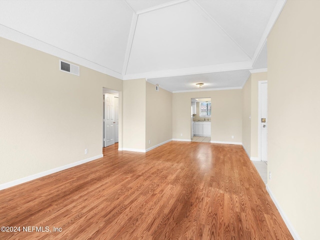 unfurnished living room featuring hardwood / wood-style floors, ornamental molding, and high vaulted ceiling