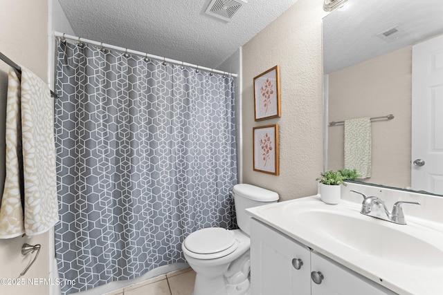 bathroom with vanity, tile patterned floors, toilet, and a textured ceiling