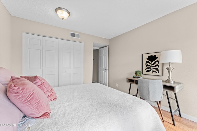 bedroom with wood-type flooring and a closet