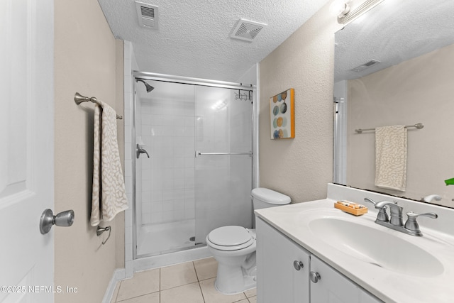 bathroom featuring tile patterned floors, toilet, an enclosed shower, a textured ceiling, and vanity