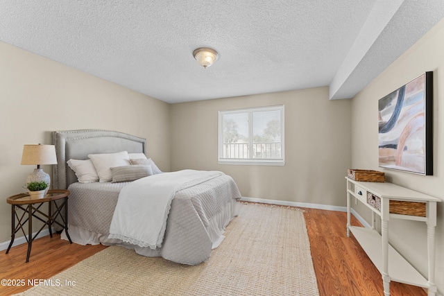 bedroom with hardwood / wood-style flooring and a textured ceiling