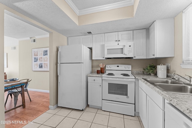 kitchen with light tile patterned flooring, white cabinetry, sink, ornamental molding, and white appliances