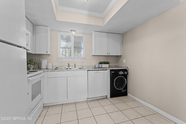 kitchen featuring white appliances, white cabinetry, a textured ceiling, washer / dryer, and a raised ceiling