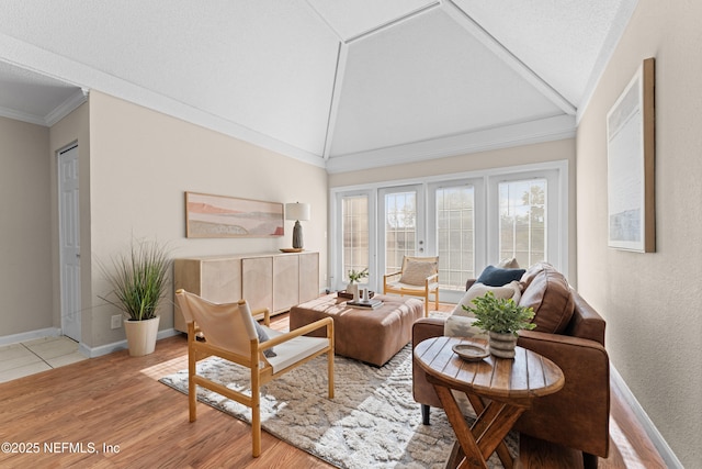 living room with ornamental molding, lofted ceiling, and light hardwood / wood-style floors