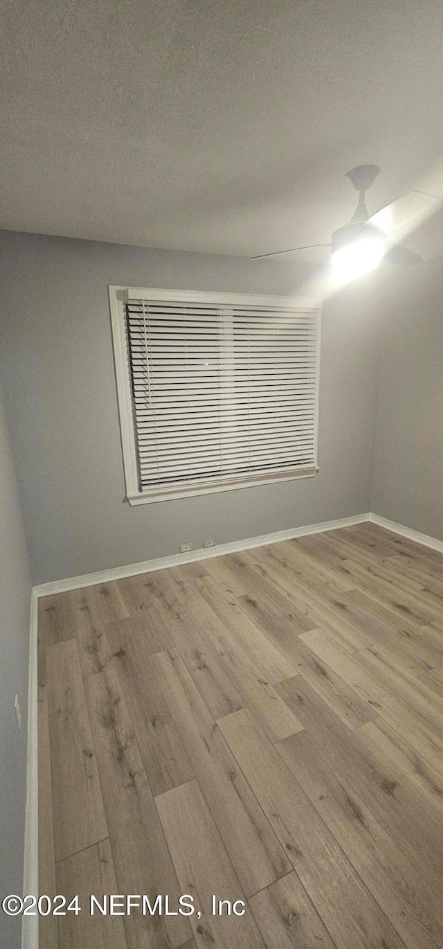 unfurnished room featuring wood-type flooring and a textured ceiling