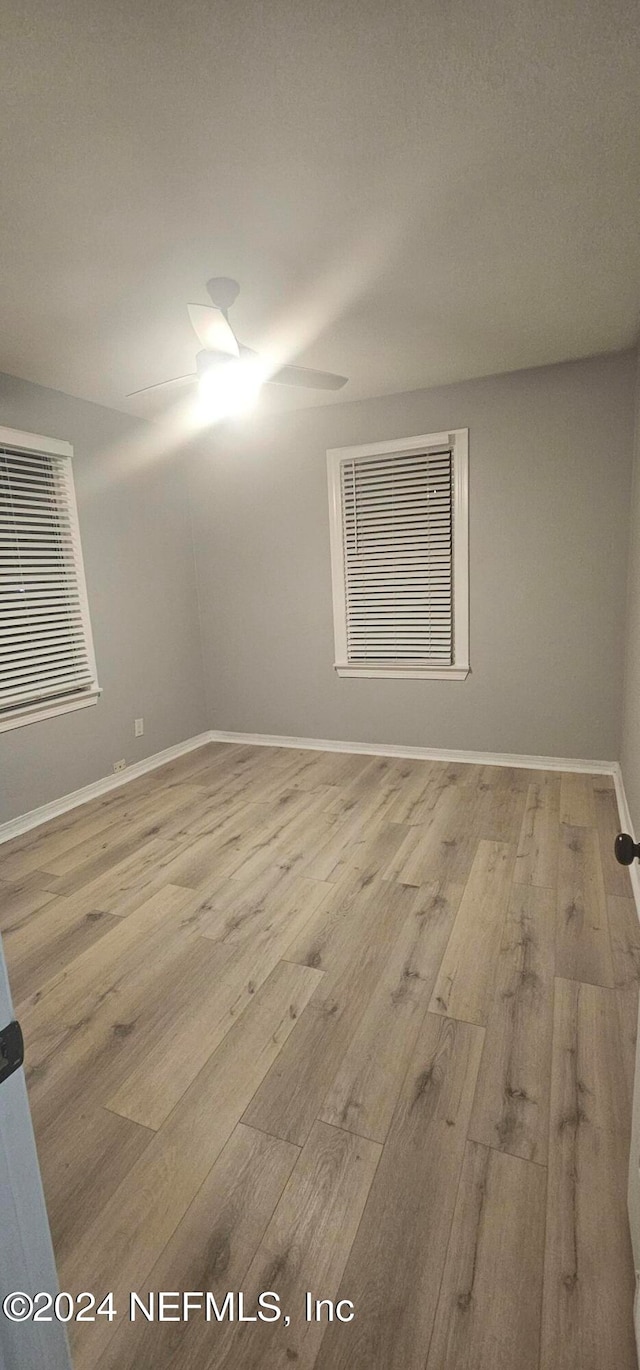 empty room with ceiling fan and wood-type flooring