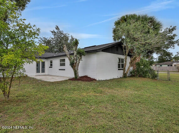 back of house featuring a patio and a lawn