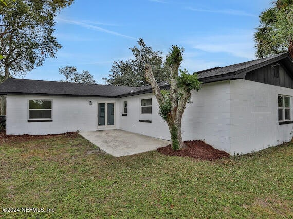 back of property featuring a patio and a yard