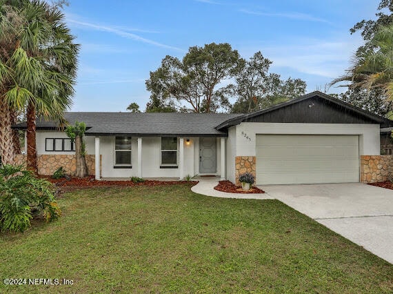 single story home featuring a front lawn and a garage