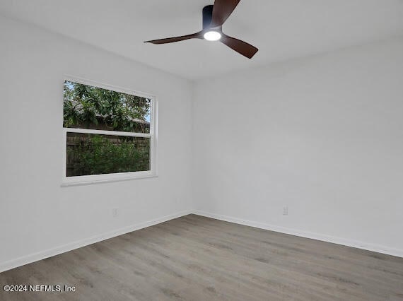 empty room with hardwood / wood-style flooring and ceiling fan