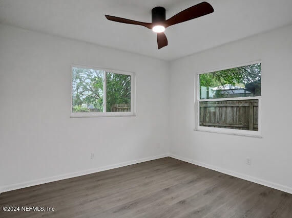 unfurnished room featuring ceiling fan and dark hardwood / wood-style flooring