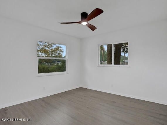 unfurnished room with a healthy amount of sunlight, hardwood / wood-style flooring, and ceiling fan