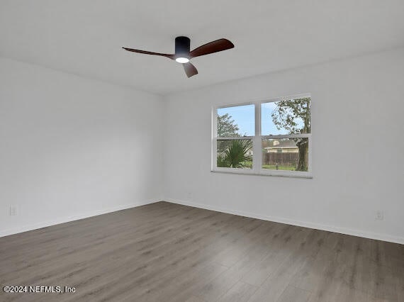 spare room featuring ceiling fan and dark hardwood / wood-style floors