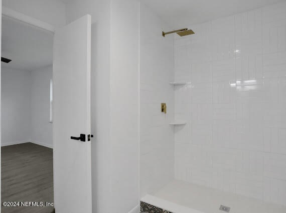 bathroom featuring hardwood / wood-style floors and a tile shower