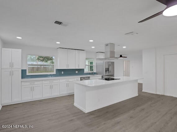 kitchen featuring light wood-type flooring, a center island, and white cabinets