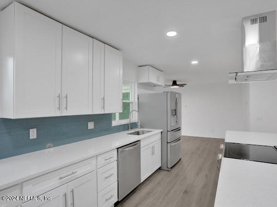 kitchen with white cabinetry, appliances with stainless steel finishes, sink, and ventilation hood