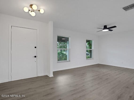 foyer entrance with ceiling fan with notable chandelier and dark hardwood / wood-style flooring