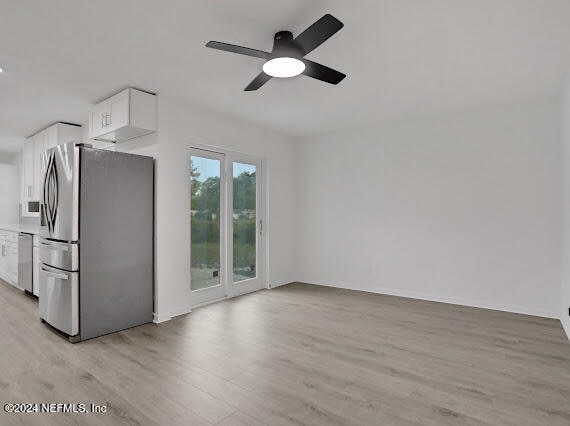 unfurnished living room featuring light wood-type flooring and ceiling fan