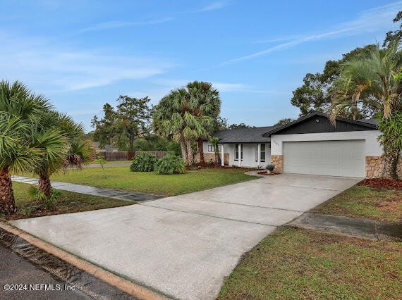 ranch-style home with a front lawn and a garage