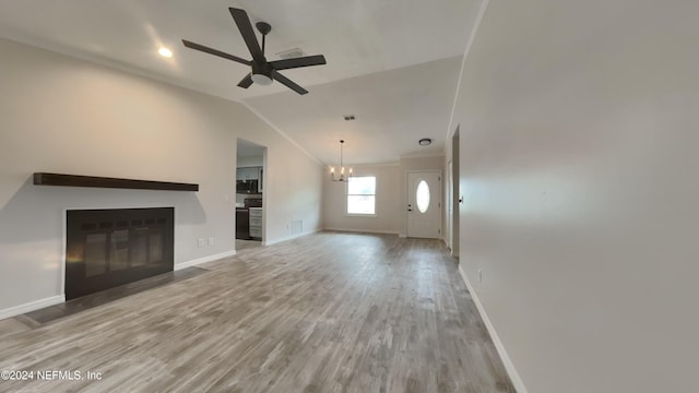 unfurnished living room featuring hardwood / wood-style floors, ceiling fan with notable chandelier, and lofted ceiling