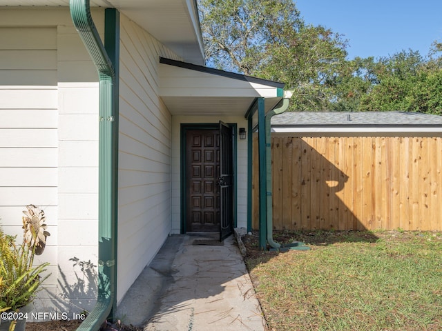 view of exterior entry featuring a yard