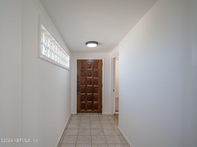 doorway with light tile patterned floors