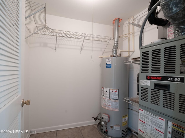 utility room with gas water heater and heating unit