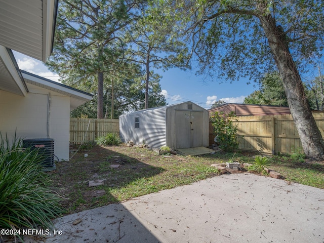 view of yard with a patio area, cooling unit, and a storage unit