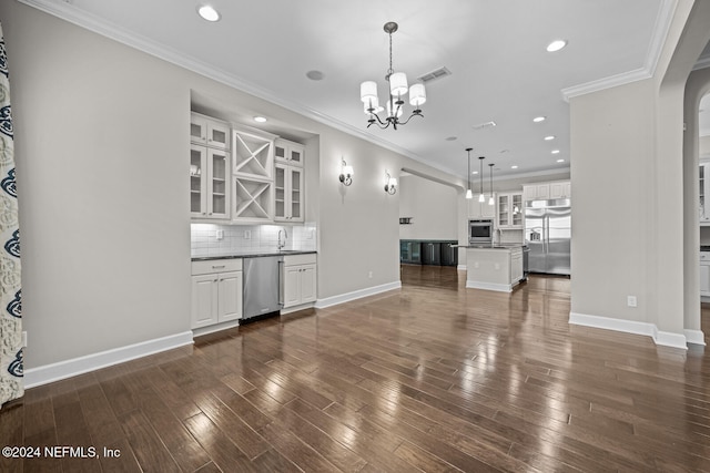 unfurnished living room featuring a chandelier, crown molding, dark wood-type flooring, and sink