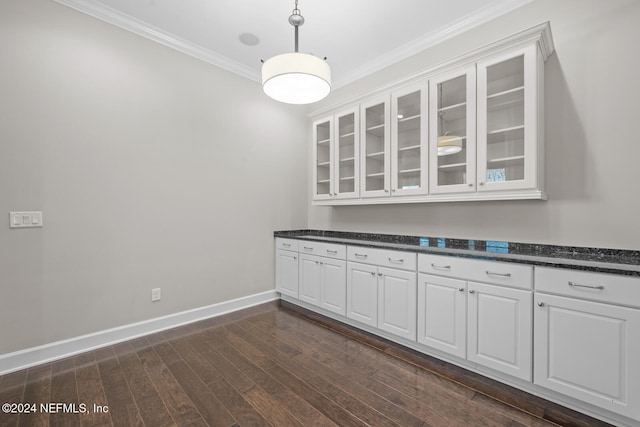 unfurnished dining area with crown molding and dark wood-type flooring